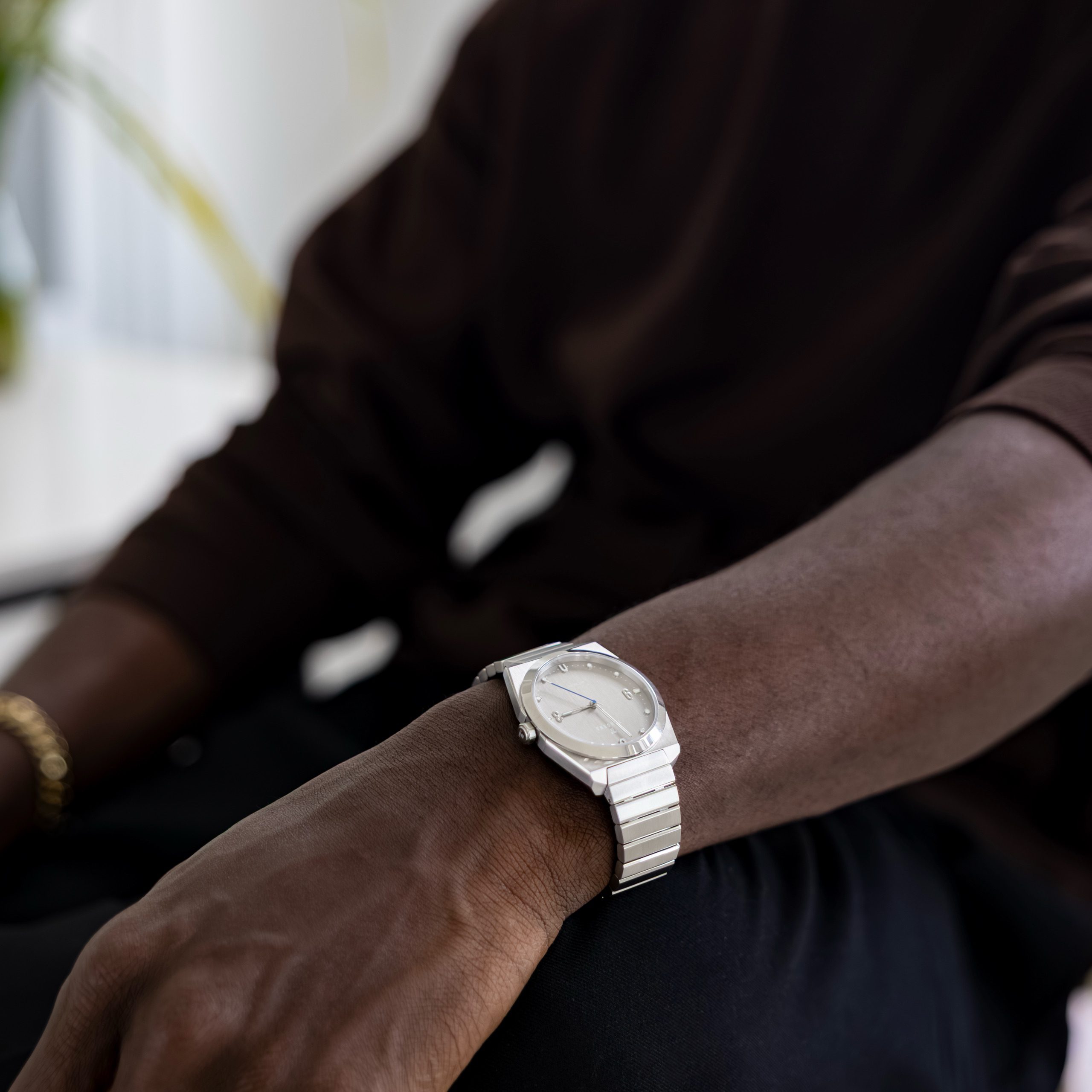 A Komposition Automatic Matte Steel on a wrist resting on a knee